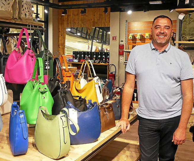 Intérieur de la boutique avec le dirigeant et une présentation de sacs à mains cuir à Lanester